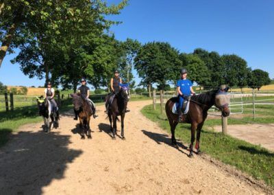 Vier Reitschüler in der Natur